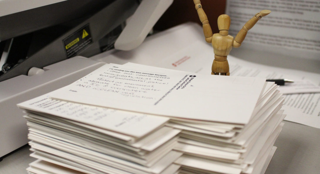 image of a Stack of Post Cards with happy figurine behind it