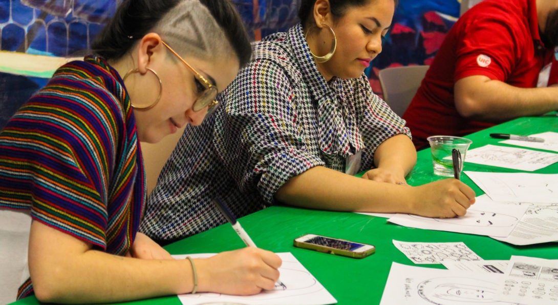 image of two people drawing political cartoons